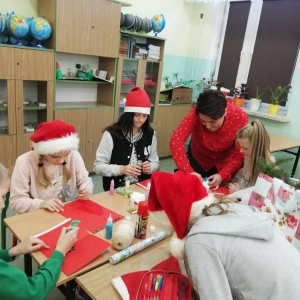 Grupa uczniów i ich wychowawczyni robią karki świąteczne