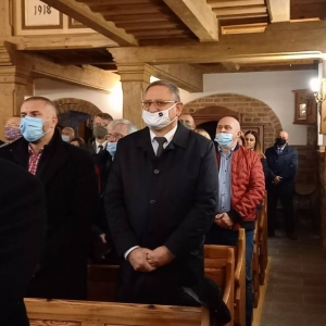 Uczestnicy mszy stoją w ławach kościelnych