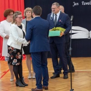 Dyrektor przyjmuje gratulacje od dyrekcji szkół gminnych, obok stoi z upominkiem dyrektor ZASiP w Olsztynku