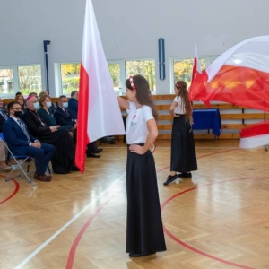 Taniec z flagami – uczennice w dwóch rzędach machają flagami