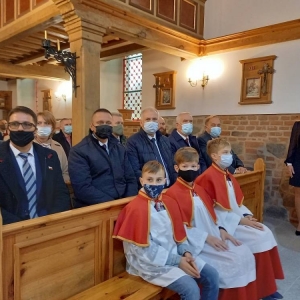 Dyrektor i przedstawiciele władz, 3 ministrantów siedzą w kościele