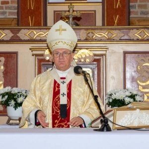 Arcybiskup stoi za ołtarzem