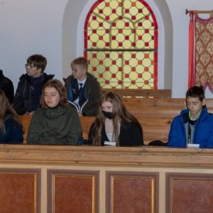 4 uczennice, 5 uczniów i wychowawczyni oddziału VIII a siedzą w ławkach twarzami zwróceni w stronę ołtarza