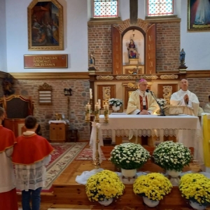 Arcybiskup prowadzi mszę stojąc za ołtarzem.