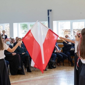 Taniec z flagami – uczennice ustawiają się parami z flagami, publiczność przygląda się