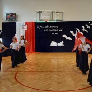 Taniec z flagami – 8 uczennic kończy taniec, w dwóch rzędach schodzą z flagami opartymi na ramionach