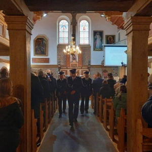 3 mężczyzn, asysta OSP w Waplewie, idzie środkiem kościoła w kierunku wyjścia