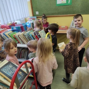 Na zdjęciu grupa dzieci przeglądających książki.