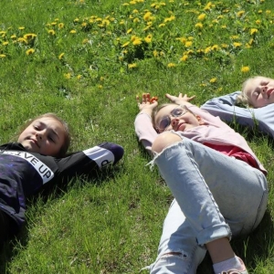 Trzy dziewczynki leżą na trawniku.