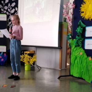 Siódmoklasistka odczytuje treść wiersza o Ziemi ułożonego wspólnie z koleżanką.