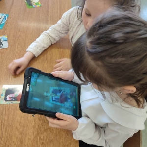 Dwie dziewczynki podczas pracy z kartami 4d. Na aplikacji słuchają informacji i wyświetlają jedno ze zwierząt morskich. 
