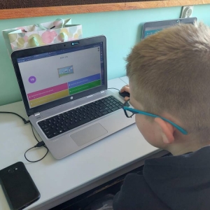 Uczeń, podczas zajęć j. angielskiego, siedzi przed laptopem i rozwiązuje quiz online.
